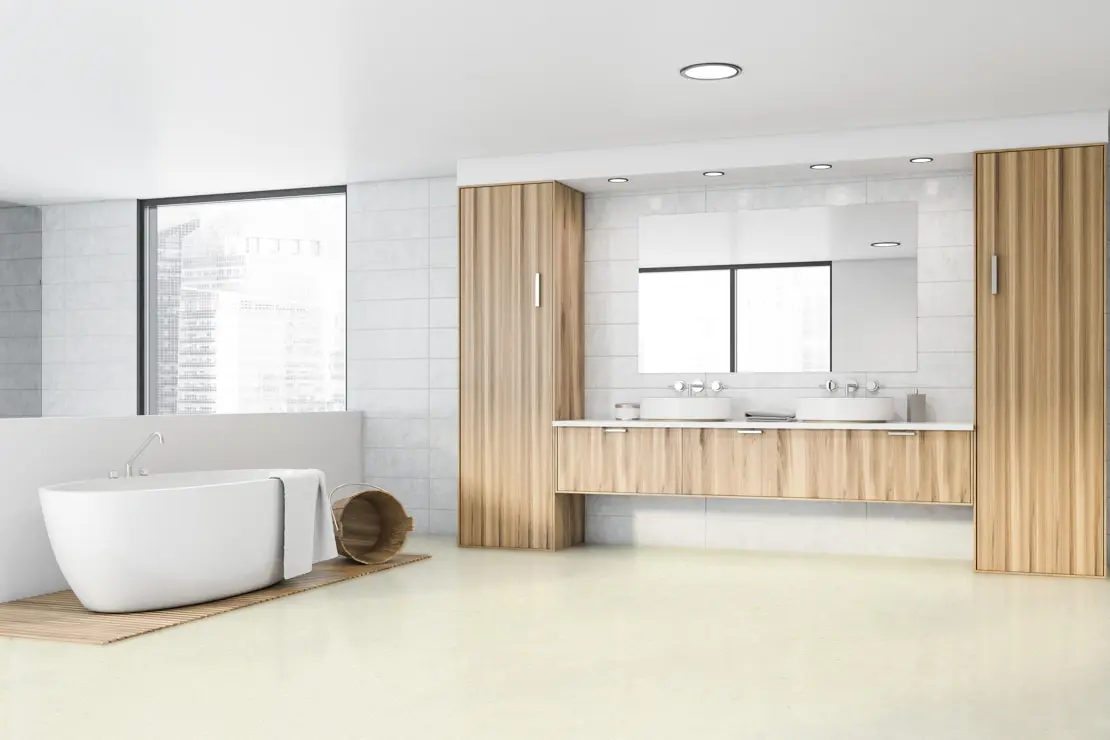 Баня в минималистичен стил с под от микроцимент, самостоятелна вана и дървени завършващи детайли около двойната мивка