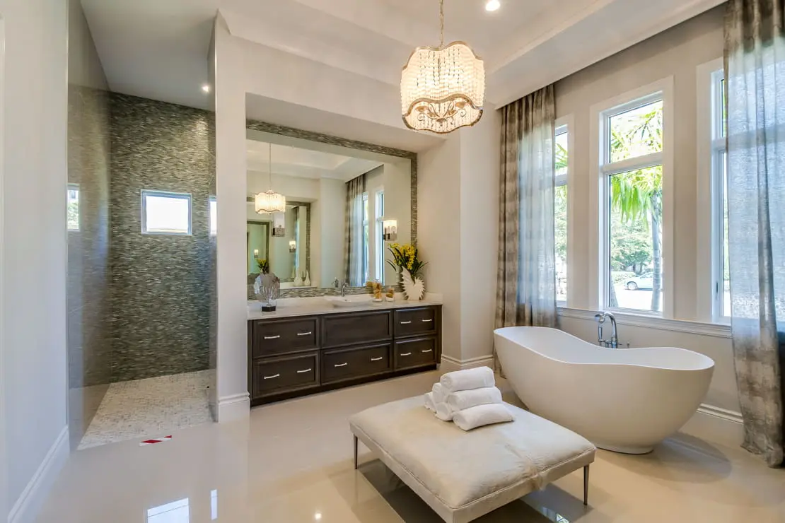 Luxury bathroom with double sink, black built-in faucets and a bathtub at the back of the room
