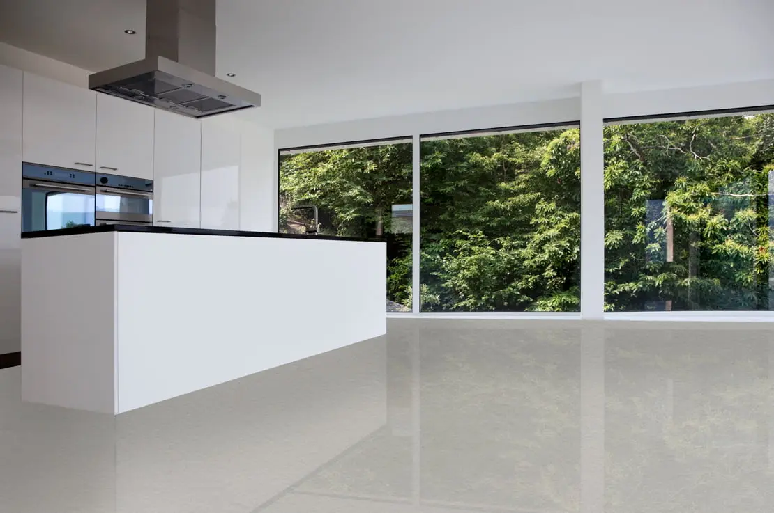 Mikrosementtilattia minimalistisessa keittiössä, jossa on liesituuletin ja suuret ikkunat