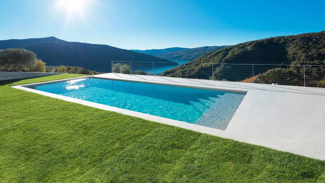 Piscine en béton ciré dans un jardin avec vue sur les montagnes