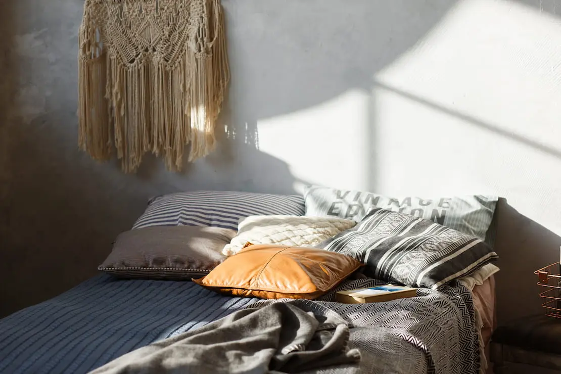 Boho chic stil kao dekoracija spavaće sobe s mikrocementnim zidom