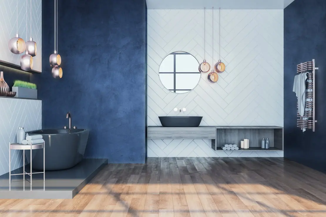 Microcimento na parede de uma casa de banho onde convivem os azulejos e o chão de madeira