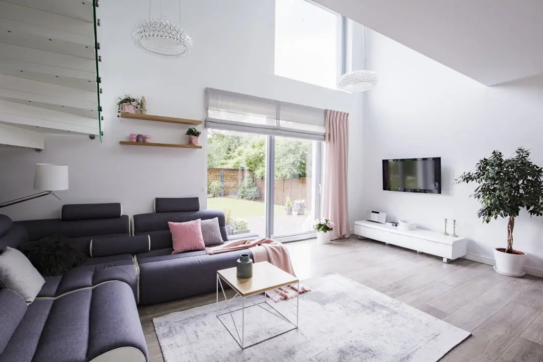Moderna luksuzna dnevna soba okrašena v belih tonih in z lesenim tlemi